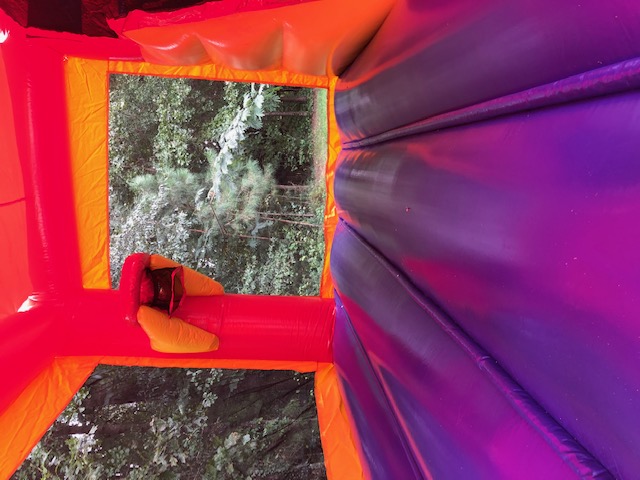 bounce house with slide and basketball hoop